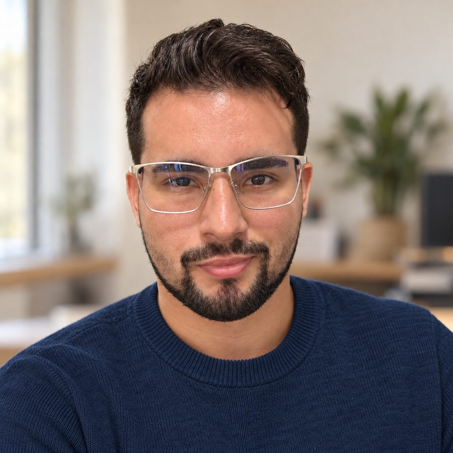 Tiago S. Araújo, de suéter azul, em um ambiente de trabalho claro